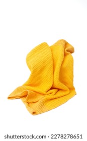 Yellow crochet blanket folds arranged on white background