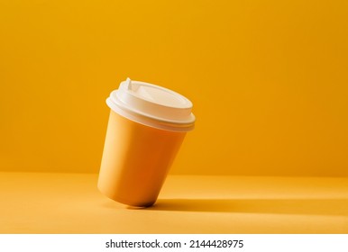 Yellow cup for coffee on a yellow background with a shadow. - Powered by Shutterstock