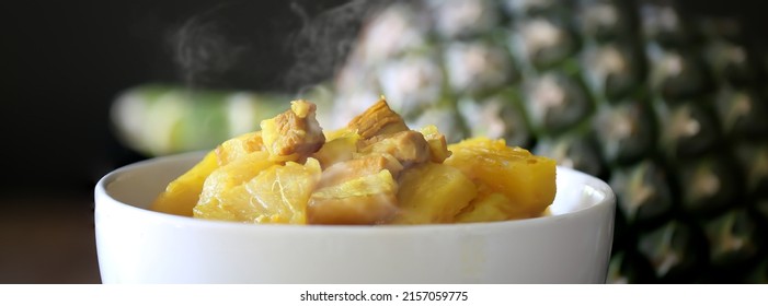 Yellow curry Pineapple with streaky pork in white bowl and black background ,      Choose focus and space for message,  and adjustment size for banner, cover, header, background