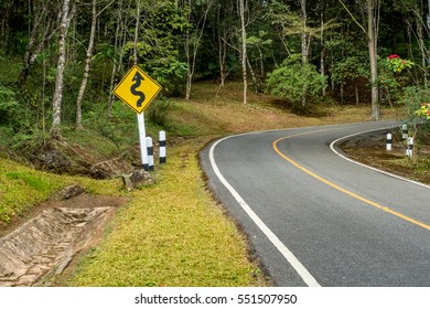 Yellow Curvey Road Sign On The Road To The Jungle