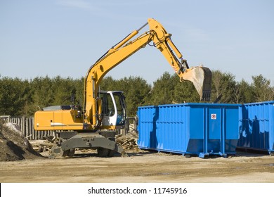 yellow demolition bulldozer beside a dumpster