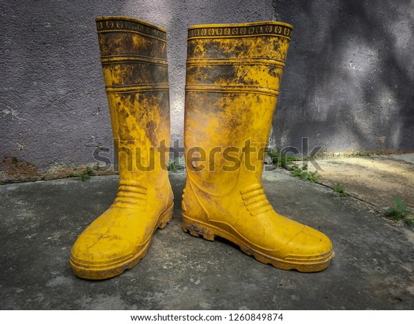 Yellow Dirty Rubber Boots Stand On 