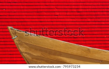 A yellow dory fishing boat with a red background