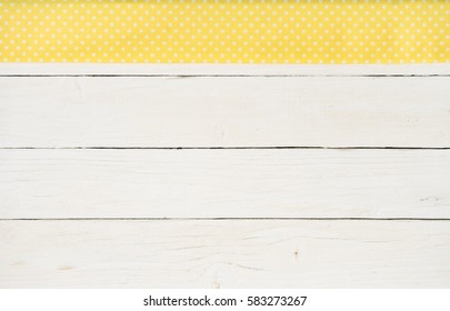 Yellow Dotted Cloth On White Wooden Table Background.