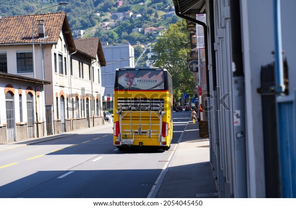 Yellow double decker post bus at City of\
Bellinzona on a sunny late summer noon. Photo taken September 11th,\
2021, Bellinzona,\
Switzerland.