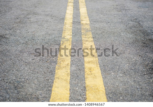 Yellow double solid\
line. Road markings on asphalt on the street. Highway surface with\
double yellow lines.