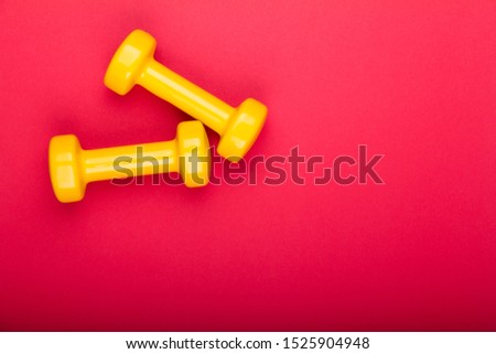 yellow dumbbells on red background