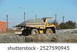 A Yellow Dump Truck is Actively Transporting Gravel at a Busy Construction Site Today. Stock Clip