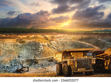 Yellow Dump Truck Loading Minerals Copper, Silver, Gold, And Other  At Mining Quarry.