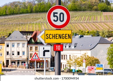 Yellow entrance road sign for Schengen town on the western bank of the river Moselle, Luxembourg. Birthplace of Schengen Agreement, common visa policy, which abolished passport and border control.  - Shutterstock ID 1700094934