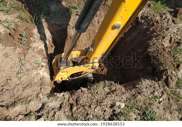 The yellow excavator digs a
trench, construction works by means of automobile
equipment.new