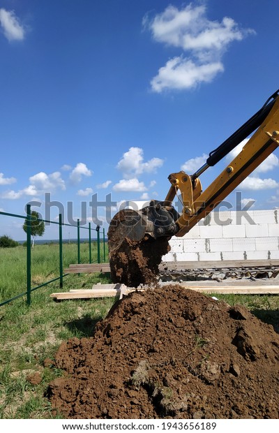 The yellow excavator digs a\
trench, construction works by means of automobile\
equipment.new