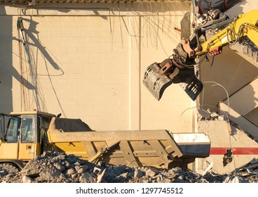 Yellow Excavator With Grab Attachment Loading A Truck