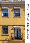 Yellow facade with large windows and balconies. Lisbon, Portugal