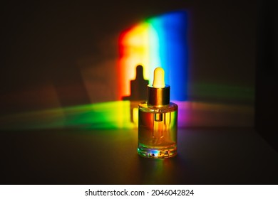 Yellow Face Oil With A Dropper Bottle In Rainbow Prism Light. Side View