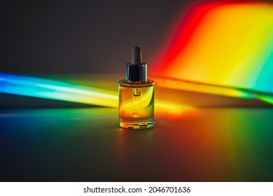 Yellow Face Oil With A Dropper Bottle In Rainbow Prism Light. Side View