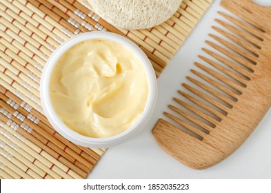 Yellow facial mask (banana face cream, shea butter hair mask, body butter) in the small white container. Natural skin and hair concept. Top view, copy space.