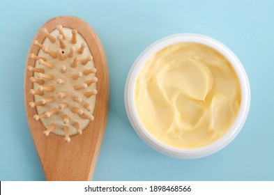 Yellow facial mask (banana face cream, shea butter hair mask, body butter) and wooden hairbrush. Natural skin and hair concept. Top view, copy space.