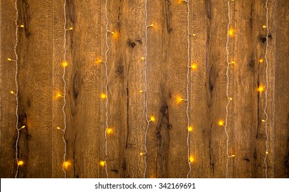 Yellow Fairy Lights On A Wooden Wall - Holyday Background.