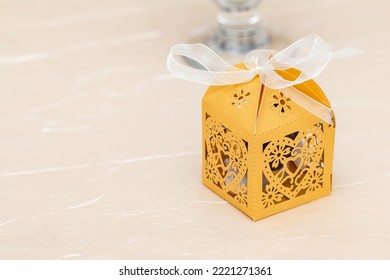 Yellow favor party box on the table. Wedding favors for guests. Paper gift box. - Shutterstock ID 2221271361