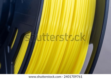 Yellow filament of plastic for printing on 3D printer. Spools of 3D printing motley thermoplastic filament. ABS, PLA, FDM wire plastic for 3d printer.