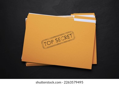 Yellow file with documents and Top Secret stamp on black table, top view - Shutterstock ID 2263579495