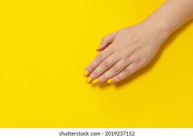 Yellow Finger Nail Point Isolated Yellow Background With Nail Polish. Painting Nails.