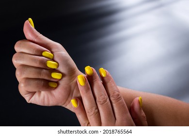 Yellow Finger Nails Close Up, On Black Background With Copy Space.