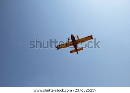 Yellow firefighters plane on sky with sun light in background