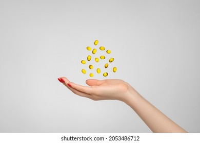 Yellow Fish Oil Pills Hover Over Hand