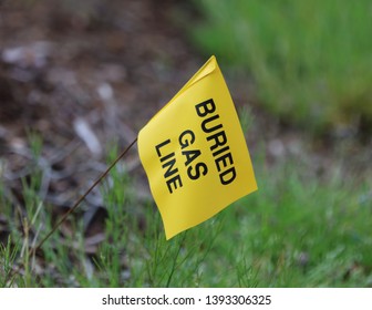 Yellow Flag With A Green Grass Background Marks The Location Of A Buried Gas Line To Prevent Accidental Rupture During Excavation