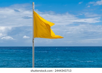 Yellow flag on the beach in summer summer, lifeguards sign - Powered by Shutterstock