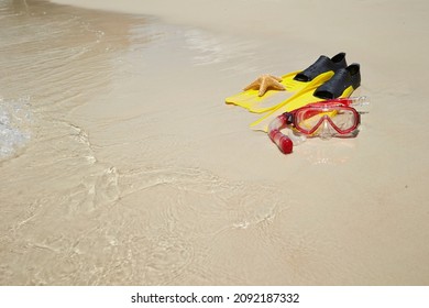 Yellow Flippers, Snorkel Set And Starfish On The Beach