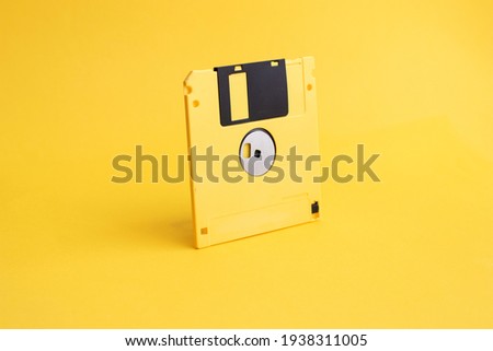 Yellow floppy disk on yellow background.