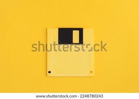 Yellow floppy disk on yellow background.