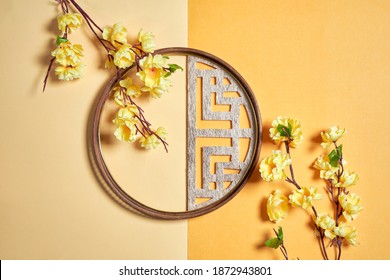 Yellow flower cherry blossom branch and Chinese traditional round window on yellow background                     - Powered by Shutterstock