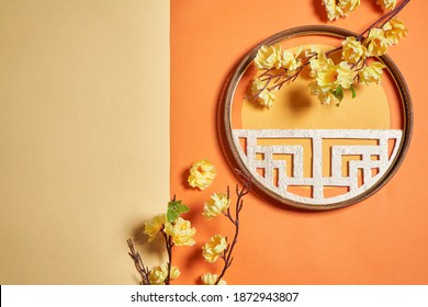 Yellow flower cherry blossom branch and Chinese traditional round window on orange background                          - Powered by Shutterstock