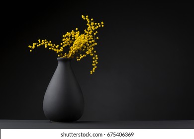 yellow flower on the black vase 