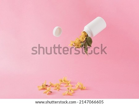 Yellow flowers come out of the plastic container bottle against pink pastel color.Creative summer of spring concept.Season background idea.