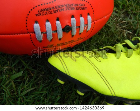 Yellow football boot and football on grass background