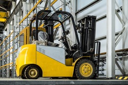 Yellow forklift truck in a industrial warehouse building, an Industrial Photo by N-sky