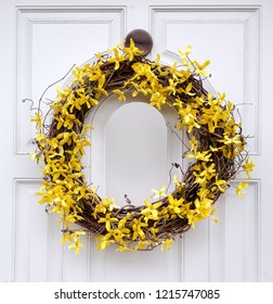 Yellow Forsythia Wreath On White Front Door.