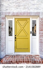 Yellow Front Door With A Brick Entrance, White Walls And A Brick Wall