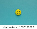 Yellow funny smiley face on blue background. Positive mood concept