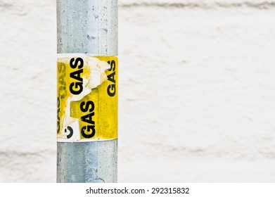 Yellow gas labels on a metal post