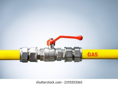 Yellow gas pipe with valve on grey background with copy space. Gas transportation system. Repair concept.