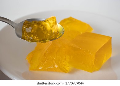 Yellow gelatine on a plate on a white background