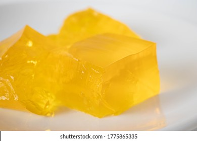 Yellow gelatine on a plate on a white background