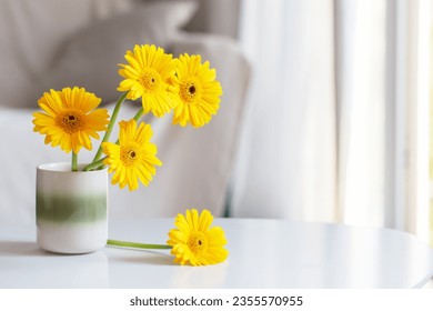 yellow gerbera in ceramic vase in light living room - Shutterstock ID 2355570955