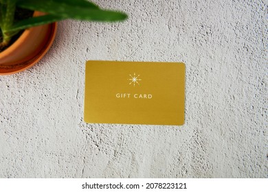 Yellow gift card with Aloe on a grey background.